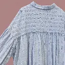 Detalhe traseiro de camisa azul-pálida.webp
